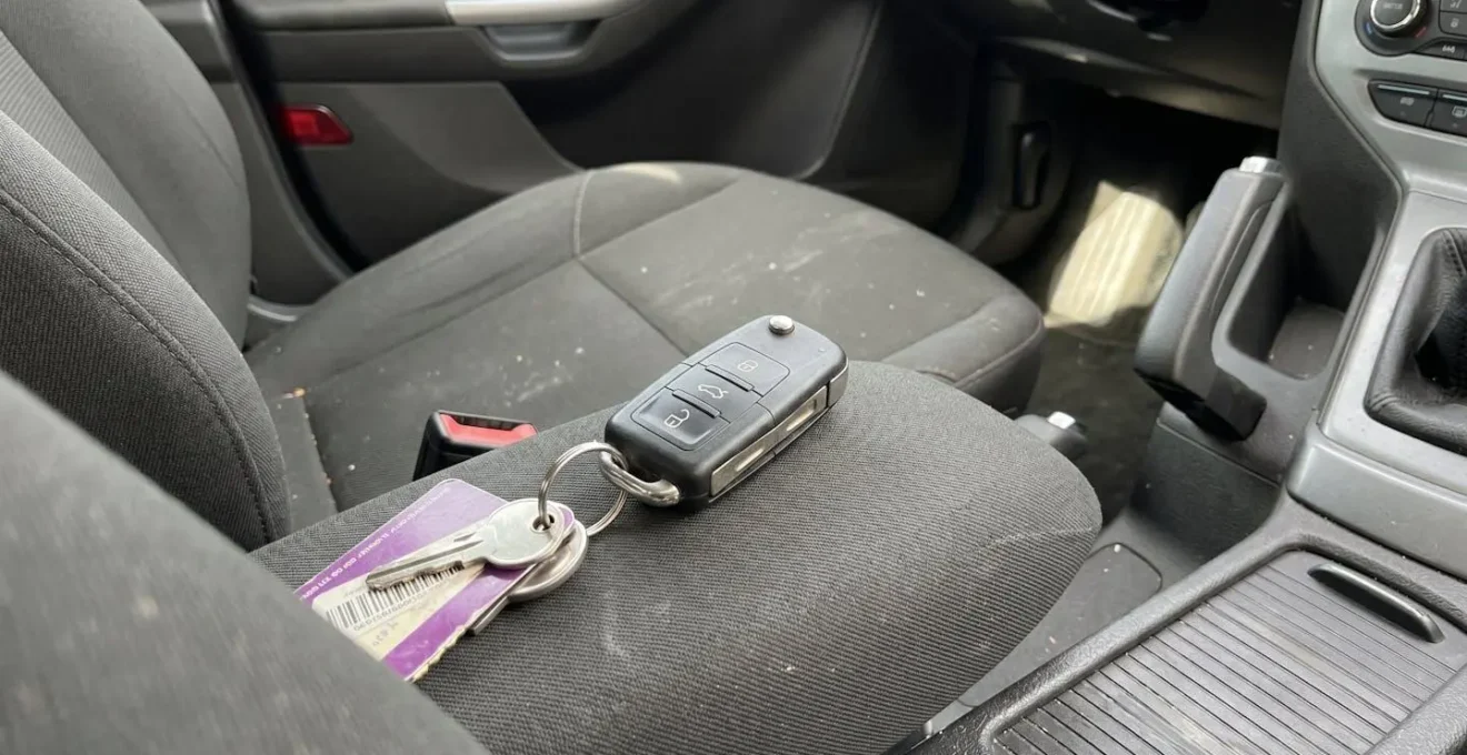 Gros plan sur une clé de voiture électronique moderne avec télécommande intégrée posée sur un tableau de bord contemporain